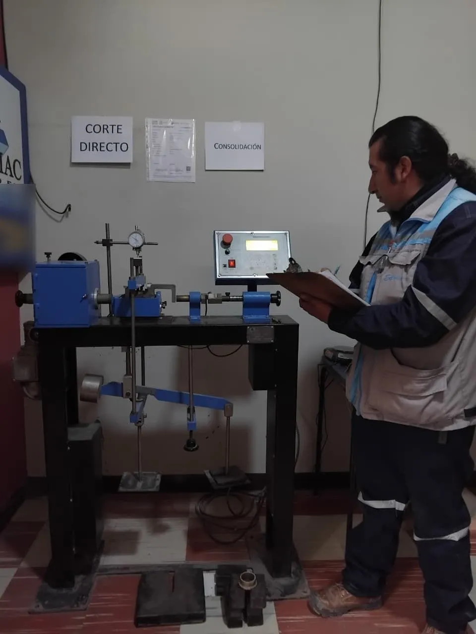 Técnico con tablero de notas junto al equipo de corte directo.